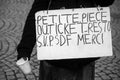 Homeless man with placard in french : petite piece, ticket restaurant SVP merci, in english : small coin, restaurant