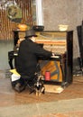 Homeless man playing piano on street with stray dog