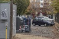 Homeless man with a shopping trolley bag scavening in the trash Royalty Free Stock Photo