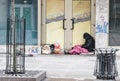 Homeless man siting in cold weather at closed door shop in Wroclaw, Poland