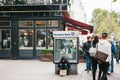 Berlin, October 22, 2017: unemployed man is sitting next to the billboard of Deutsche Bank next to people passing by