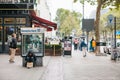 Berlin, October 2, 2017: unemployed man is sitting next to the billboard of Deutsche Bank next to people passing by