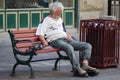 Homeless Man Sitting on a Park Bench on Stephen Avenue in Calgary Alberta Royalty Free Stock Photo