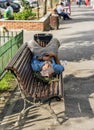 Homeless man sleeping on a bench in daylight