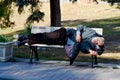 A homeless man sleeping on bench park