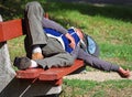 Homeless man is sleeping on a park bench Royalty Free Stock Photo