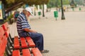 Homeless man sleeping while sitting on a Black Sea-front bench