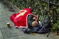 Homeless man sleeping under a blanket on the street of a European city