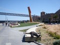 Homeless man sleeps on concrete slab near art