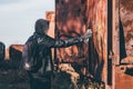 Homeless man spray painting old train wagon with aerosol can Royalty Free Stock Photo