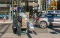 Homeless old man on a street. A homeless person struggles up a hill while carrying his cache of cans and pushing trolley Royalty Free Stock Photo