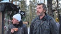 Homeless people are interviewed in the winter in the woods.