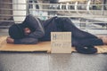 Homeless people poverty beggar man asking for money job and hoping help in helpless dirty city sitting with sign of cardboard box