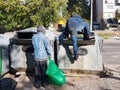 Homeless people seek food and valuables in a trash can. The disadvantaged louis carry a beggarly lifestyle. Sorting municipal