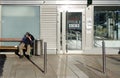 Homeless person sitting on a sunny bench Royalty Free Stock Photo