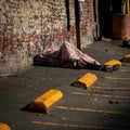 Homeless person sleeping on the ground covered in a blanket