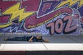 Homeless person sleeping on sidewalk in from of sign asking individuals to make Las Vegas beautiful.