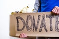 Homeless poor man holding carton board with word food DONATE Royalty Free Stock Photo