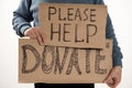 Homeless poor man holding carton board with word Please help, DONATE Royalty Free Stock Photo