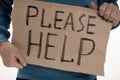 Homeless poor man holding carton board with word Please help Royalty Free Stock Photo