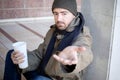 Homeless seated in the street and asking for charity Royalty Free Stock Photo