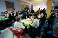 Homeless and unhealthy people sit around tables with food at the Christmas charity dinner for the homeless Royalty Free Stock Photo