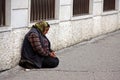 A homeless woman begs for money in the street