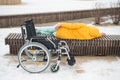 Homeless woman sleeping on a park bench next to a wheelchair. Royalty Free Stock Photo