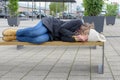 Homeless woman sleeping rough on a bench Royalty Free Stock Photo