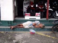 A homeless woman sleeps at the front steps of a motorcycle store