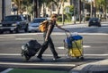 A Homeless woman walking on city street with her belongings in santa ana ca