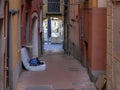 Homelessness. Unidentifiable man sleeps on old mattress in the street, Italy - Lerici.