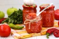 Homemade adzhika with apples in jars on a white background Royalty Free Stock Photo