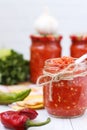 Homemade adzhika with apples in jars on a white background Royalty Free Stock Photo