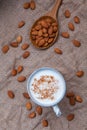 Homemade almond milk in Cup with whole almonds in wooden spoon o