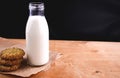 Homemade almond milk in glass bootle with oatmeal cookies on the wooden table. Organic alternative milk. Copy space. Cookies with