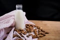 Homemade almond milk in glass bootle with oatmeal cookies on the wooden table. Organic alternative milk. Copy space. Cookies with