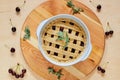 Homemade american cherry pie in a baking dish on the wooden background decorated with mint leaves and fresh cherries Royalty Free Stock Photo