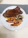 Homemade American eye steak and prawns with special garlic sauce.