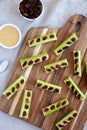 Homemade ants on a log with celery, peanut butter and raisins on a wooden board, top view. Flat lay, overhead, from above