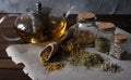 Homemade Apothecary. Natural Herbs Medicinal. Dried Herbs In Glass Jars And Teapot On Dark Wooden Surface. Various Kinds Of Herbal