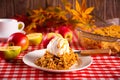 Homemade apple cramble crisp cake on white plate with autumn leaves on the background Royalty Free Stock Photo