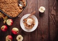 Homemade apple crumble crisp cake on white plate with autumn leaves on the wooden background Royalty Free Stock Photo