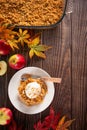 Homemade apple crumble crisp cake on white plate with autumn leaves on the wooden background Royalty Free Stock Photo