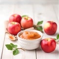 Homemade apple jam in a bowl and fresh apples on wooden background