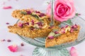 Homemade apple muesli bars with pumpkin seeds and rose petals on a light green glass cake stand Royalty Free Stock Photo