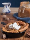 Homemade apple pie with caramel sauce and cream on a wooden table. Close-up, selective focus on the cream. Near a jar of caramel, Royalty Free Stock Photo