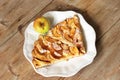 Autumn homemade apple pie - charlotte. on white ceramic plate on wooden background with fresh apples Royalty Free Stock Photo