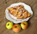 Autumn homemade apple pie - charlotte. on white ceramic plate on wooden background with fresh apples Royalty Free Stock Photo