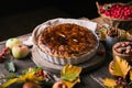 Homemade apple pie surrounded by fresh fruits, nuts, apples